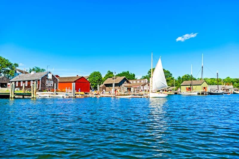 Seaport in Mystic, Connecticut with sailboat and colorful old buildings.