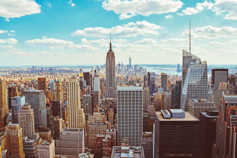 New York City skyline amongst the sky scrapers on a sunny day with blue skies.