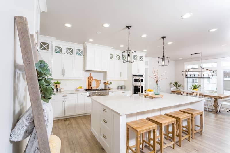 Modern farmhouse kitchen with island and hanging lights.