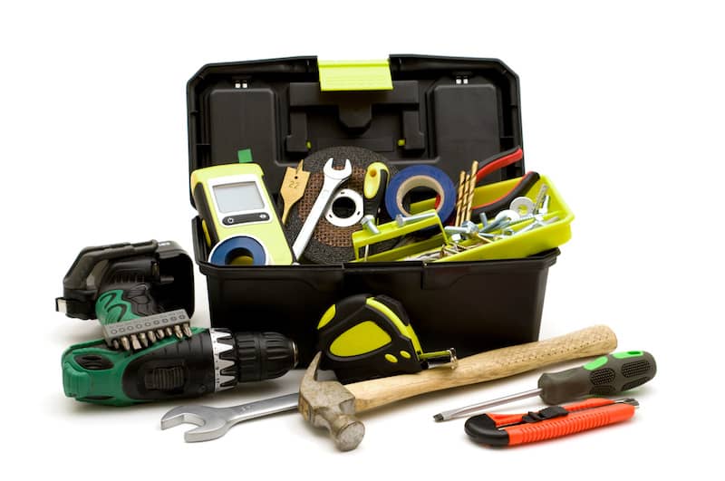 Toolbox with drill, hammer, measuring tape, and other supplies necessary for a home.