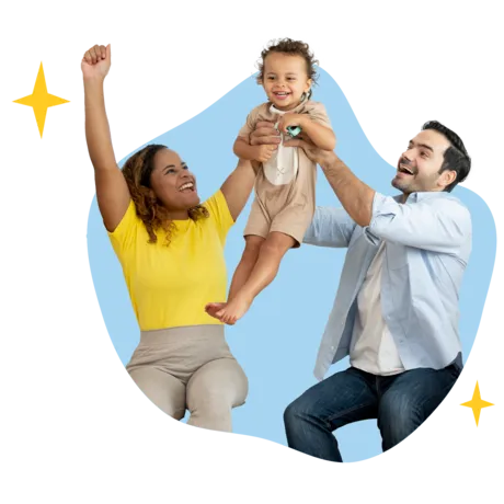 A joyful couple cheer as they raise their smiling toddler up in their arms