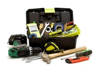 Toolbox with drill, hammer, measuring tape, and other supplies necessary for a home.