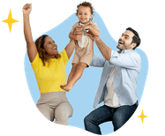 Smiling man and woman raise their laughing toddler in the air.