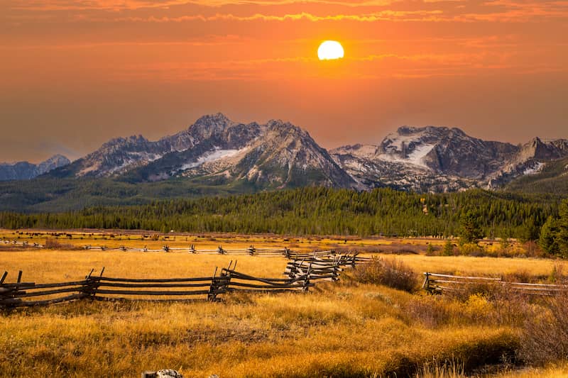 A pasture with a rustic fence in sunset in Idaho.