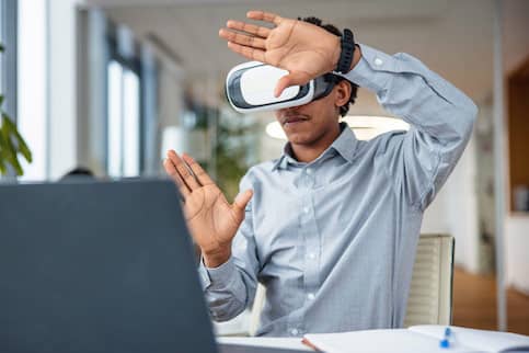 Man wearing virtual reality headset and framing hands in front of him.
