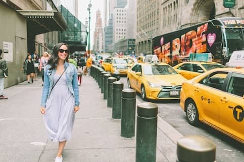 Woman walking down the sidewalk in a city.