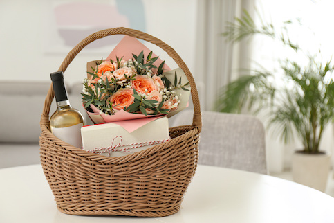 Gift basket with wine an a note and flowers.