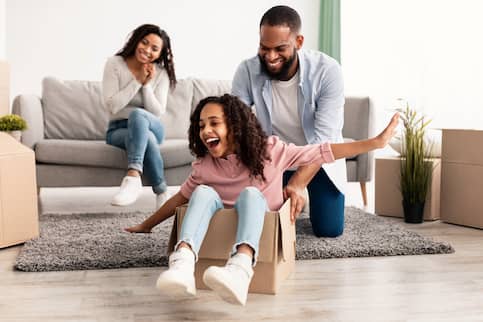 African American taking a breaking while unpacking and playing with the kids.