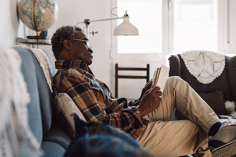 African-American senior reading at home.