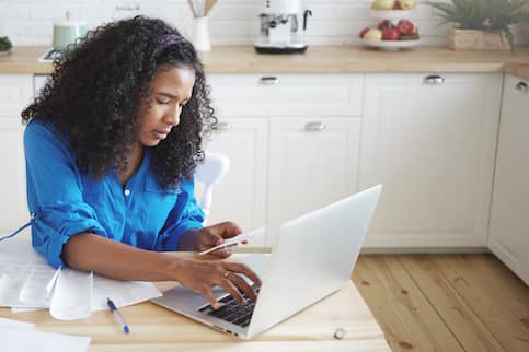 African-American woman paying bills on the computer.