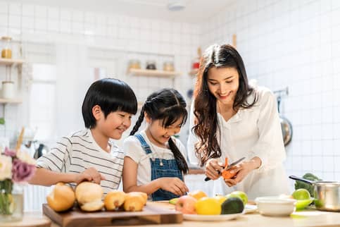 Asian mother and her two kids spending time in the kitchen together.
