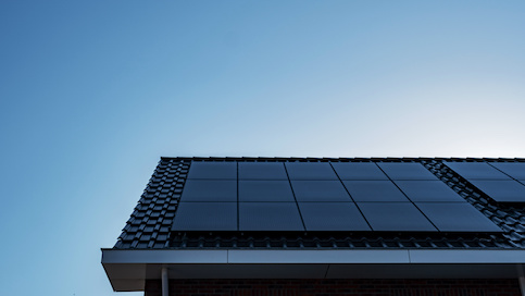 Black gabled roof with solar panels.