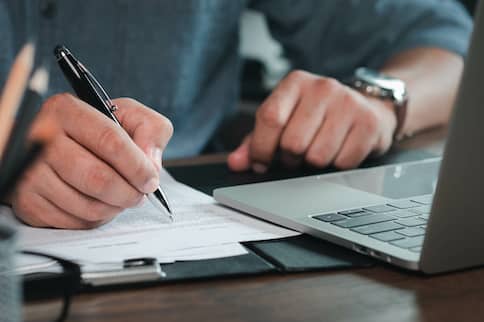 Man signing paperwork.