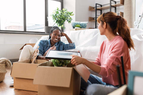 Women unpacking boxes in new home.