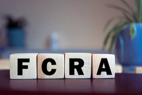 Wooden blocks on table or desk that spell out 'FCRA'.