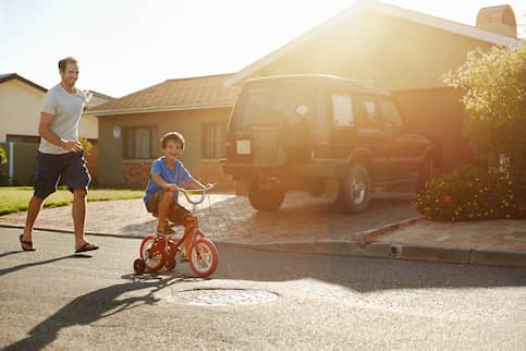 Father And Son Playing In Safe Neighborhood.