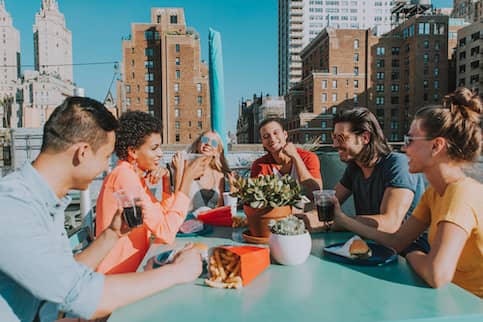 Group of many friends hanging out together on a rooftop.