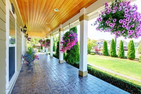 Large front porch with hanging planters.