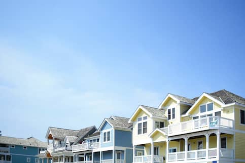 A line of colorful beach houses under a clear blue sky.