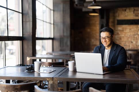 A man on his laptop working in a cafe.