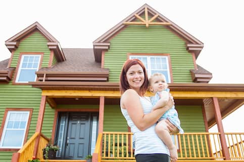 Mother and baby in front of new home.