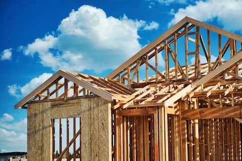 Foundation of a newly constructed house in front of a blue sky.