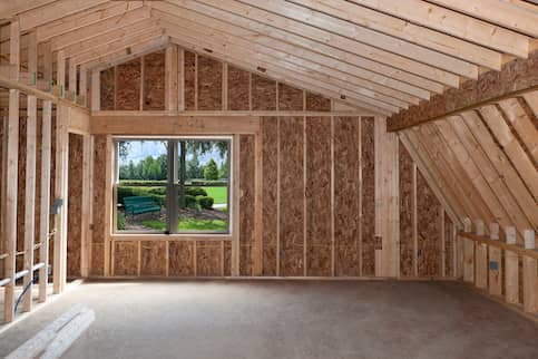 Bare and newly constructed room with single window showing an outside view.