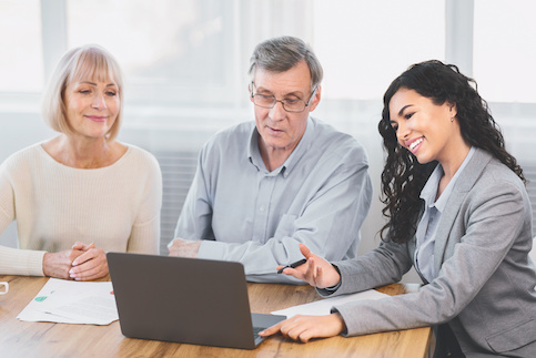 Older couple meeting with financial advisor discussing taxes.