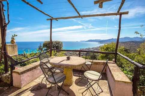 Patio with table and chairs overlooking the bay at a vacation home.