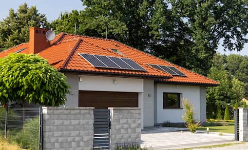 Ranch home with orange roof featuring solar panels.