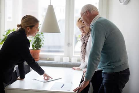 Real estate agent works with senior couple.