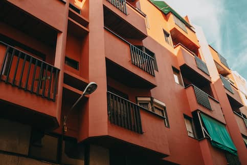 Cropped shot of a red residential apartment building with balconies,