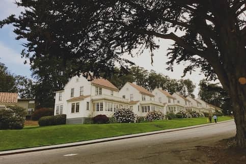 Row of white houses on quiet road.