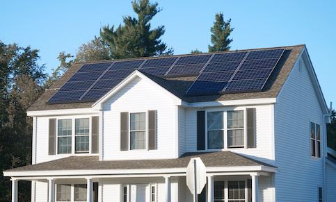 Large white house with solar panels.