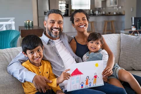 South-Asian family with childrens' drawing of home.
