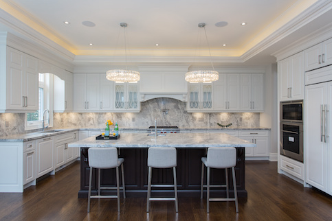 Staged remodeled white kitchen with floating bar and bar stools.