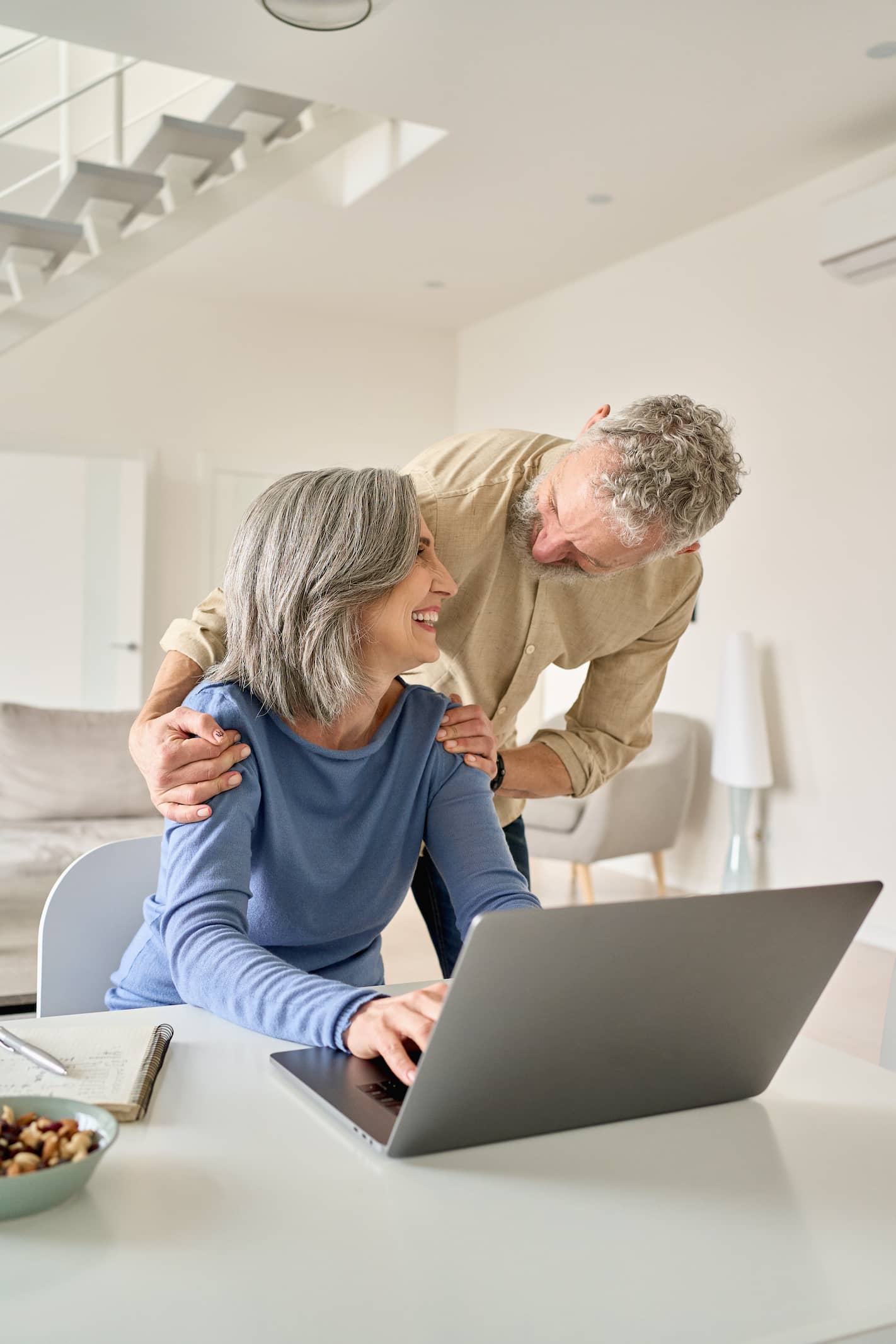 Mature couple with laptop smiling.