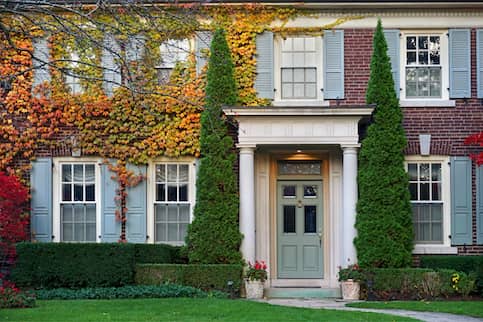 Vine covered brick home in autumn.