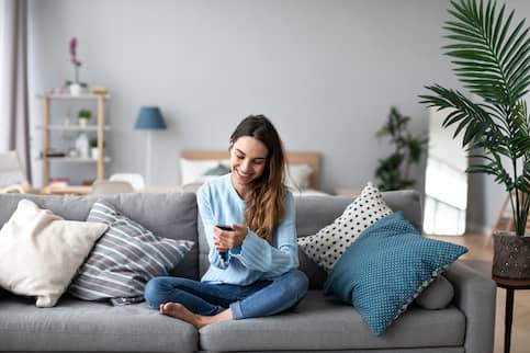 Woman on couch looking at phone.