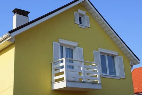 Yellow house with small balcony.