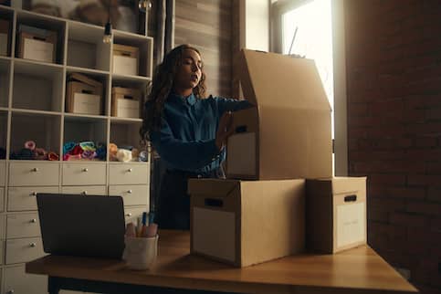 Young Asian woman unpacking a box in her home.