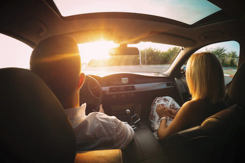 Couple driving in their new car.