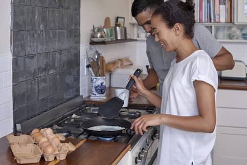 Young couple cooking breakfast together in their kitchen.