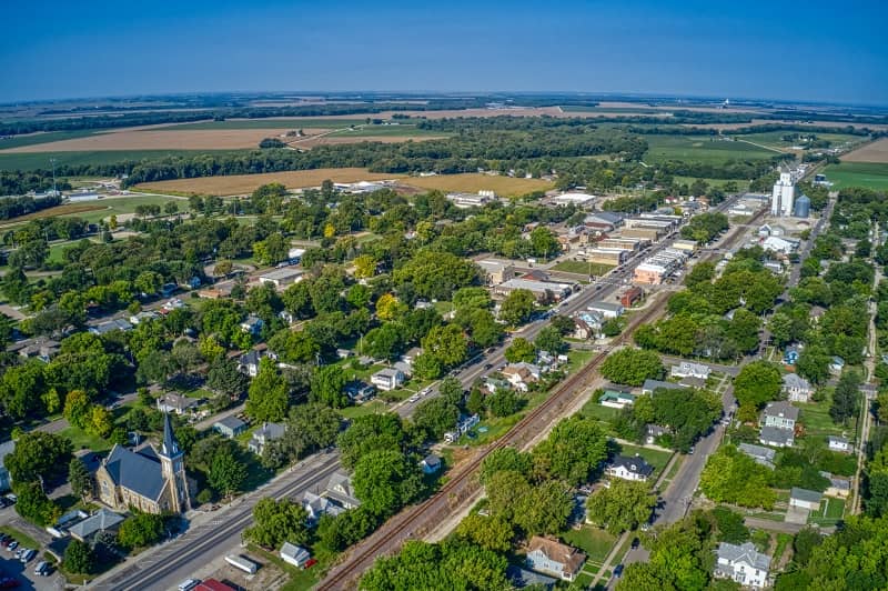 Aerial view of rural Kansas town with trees, houses, roads and railroads and farmland.