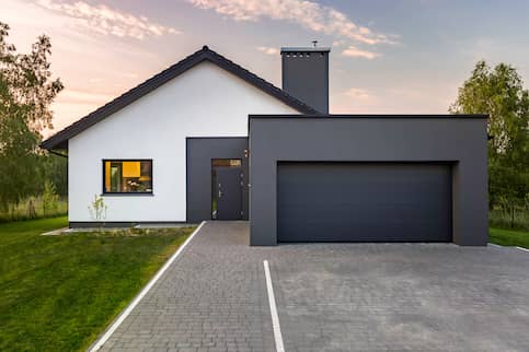 Contemporary white house with new attached dark grey garage.
