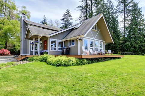 Modern farmhouse with large deck and sunny yard.