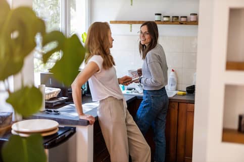Young couple in small kitchen chatting.