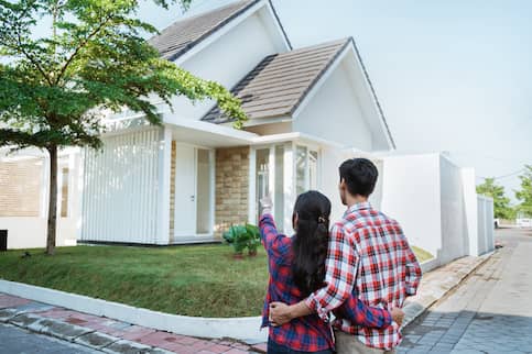 Couple pointing to house they wish to buy.