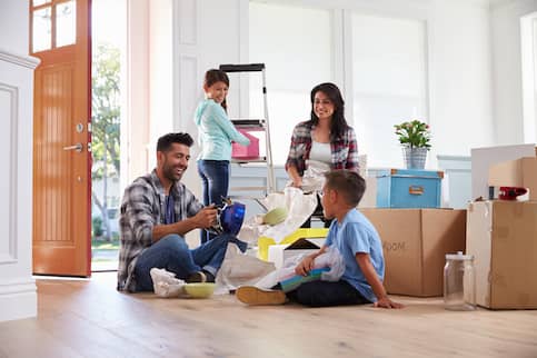 Family with two kids unpacking in new home.