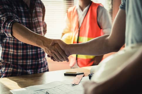 Homeowner shaking hands with contractors.